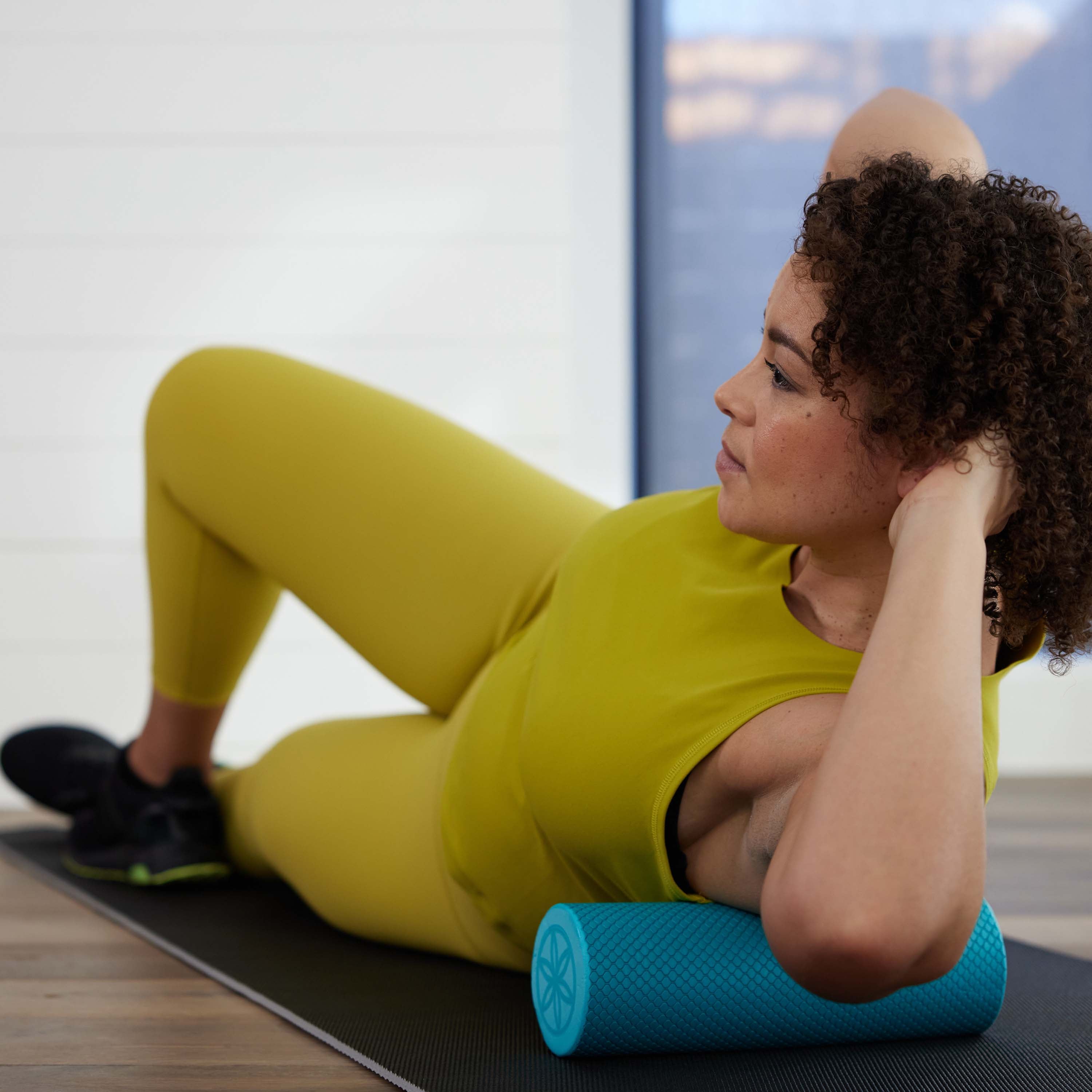 Person laying on their side with the Restore Compact Foam Roller massaging their upper side